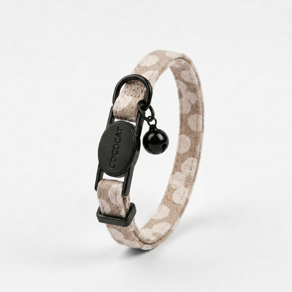 Mocha Flower-patterned cat collar with breakaway buckle, gold COCOCAT tag, and black bell.