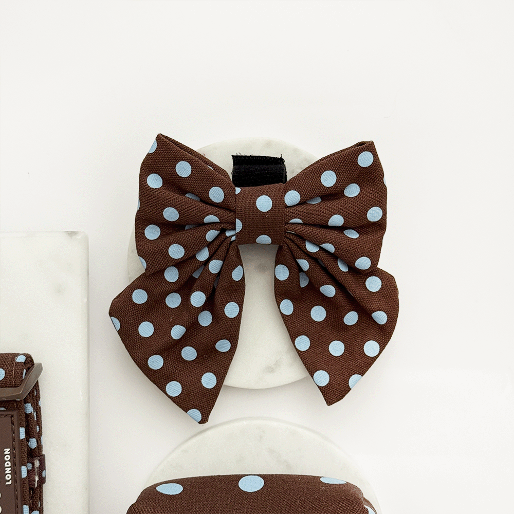 A brown dog sailor bow tie with light blue polka dot design. With velcro fastening.