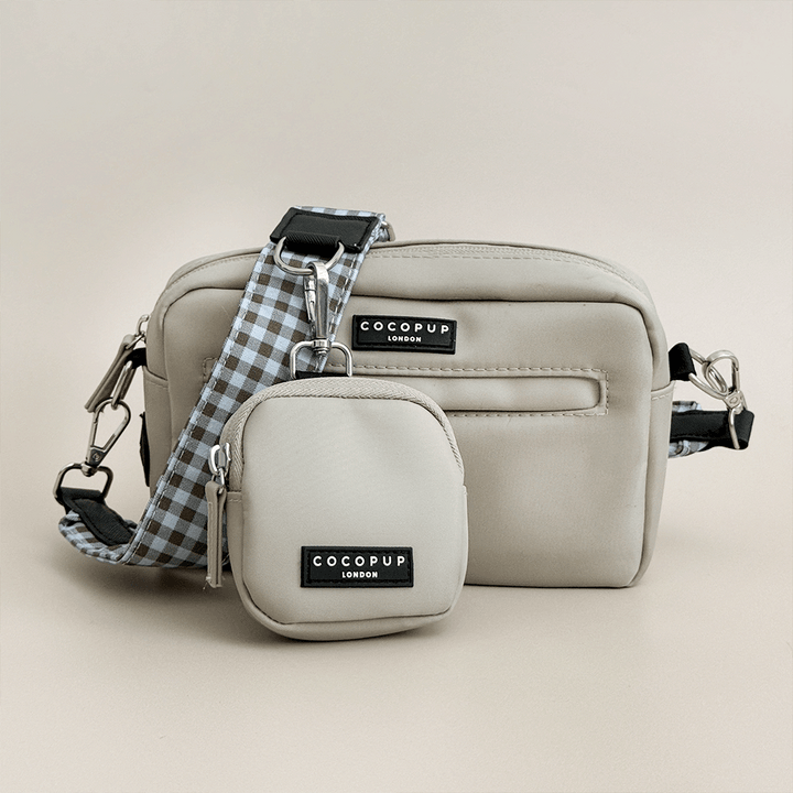 Beige Cocopup Dog Walking Bag with blue and brown bag strap attached. Also attached is a small pouch for dog treats.