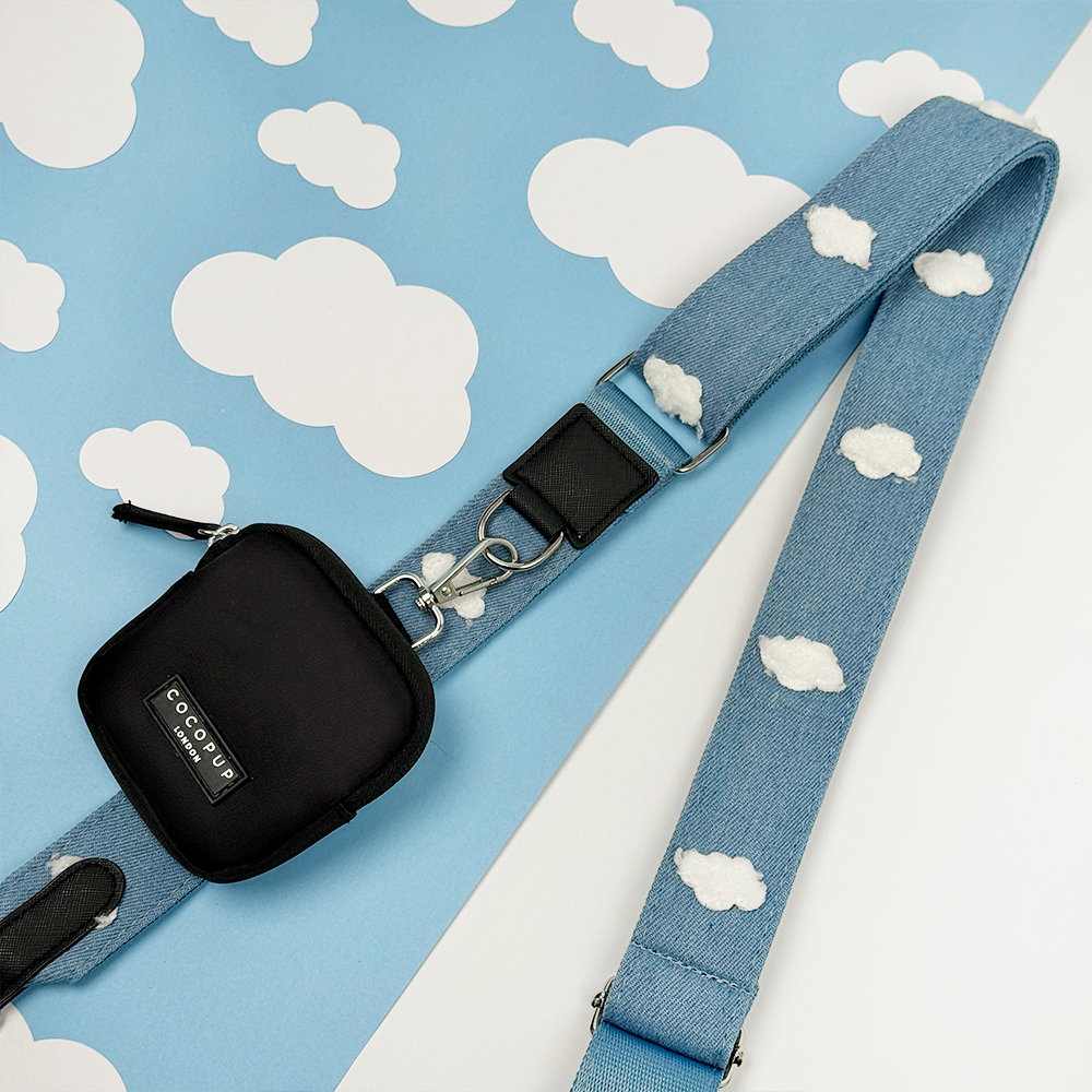 Blue Bag Strap featuring white cloud patterns on a blue background with white clouds. Attached is a Cocopup Black Treat Pouch.