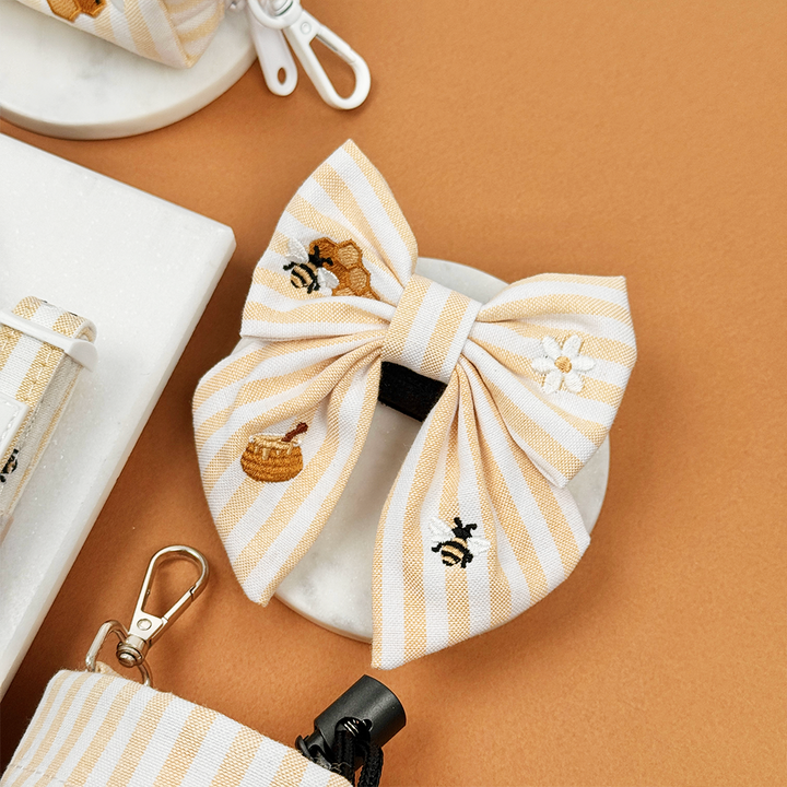 Pale yellow and white striped Dog Sailor Bow Tie with bee and honeycomb embroidered decals. 
