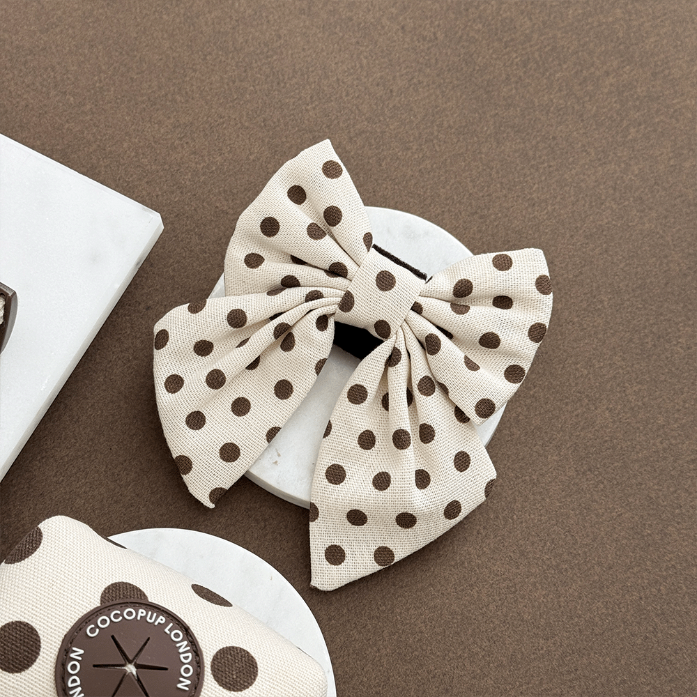 Polka dot sailor bow tie on a brown background with 'Cocopuff London' branding.