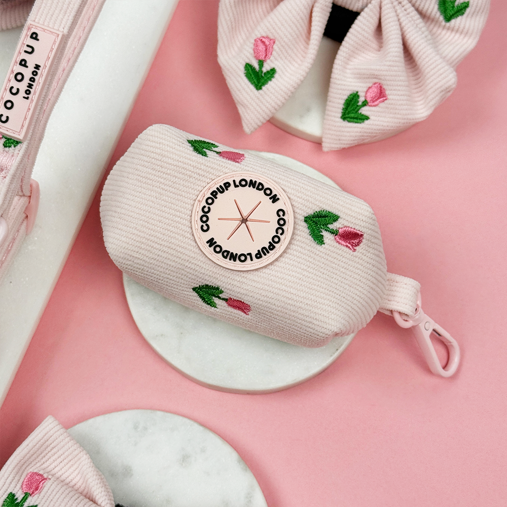 Pink dog poop bag holder with Cocopup logo and tulip embroidery design.