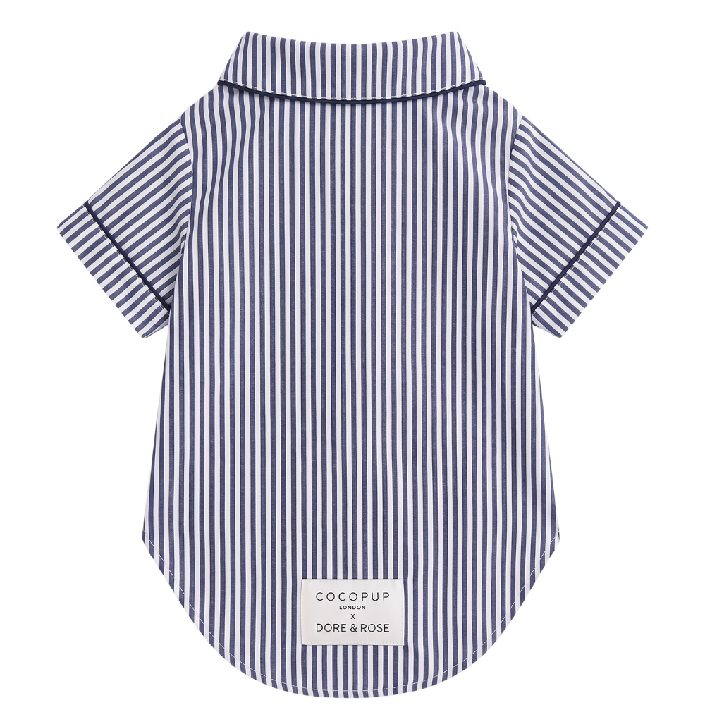A short-sleeve collared shirt with vertical navy and white stripes, featuring a white brand label at the bottom hem, shown against a plain white background.