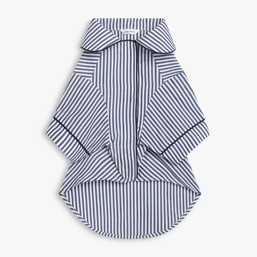 A striped dog shirt PJS with a collar and short wide sleeves, featuring vertical navy and white stripes with thin navy piping details, shown on a light gray background.